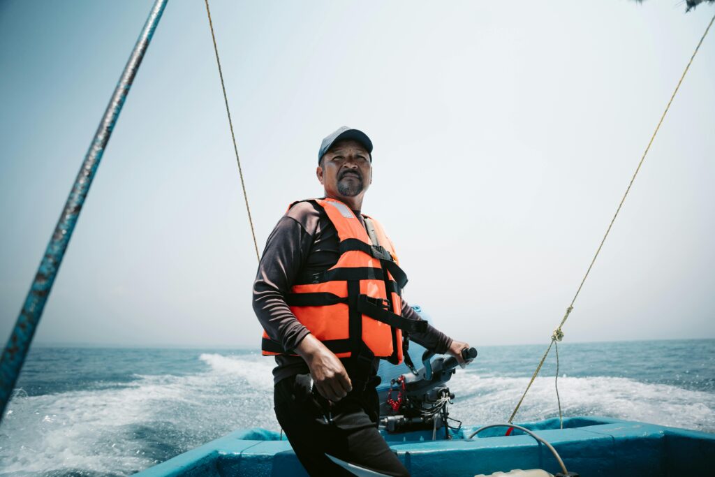 Man in life vest steering a boat on the ocean near Veracruz, Mexico.